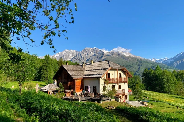 Chalet AlpeLune is located in a quiet mountain village at 1450m of Altitude. Immediately surrounded by fields where deer regularly run around. The forest starts directly above the Chalet. There is a view all-around of the most beautiful mountain peaks such as the Pelvoux 3946m with its glacier. The Ecrins massif (the National Park) and the steep rock walls with famous climbing routes can be admired from the backyard.

On the 4 sides of the chalet, you will find various seating areas for sun and/or shade, rest and/or a shared drink, a good book in one of the loungers, or a game of “jeu de boules” while the children have fun on the trampoline. 
Around the house # Holiday fun for everyone # fire pit # mini slide # slack line # swing # terrace # chicken coop # yoga in the grass #
